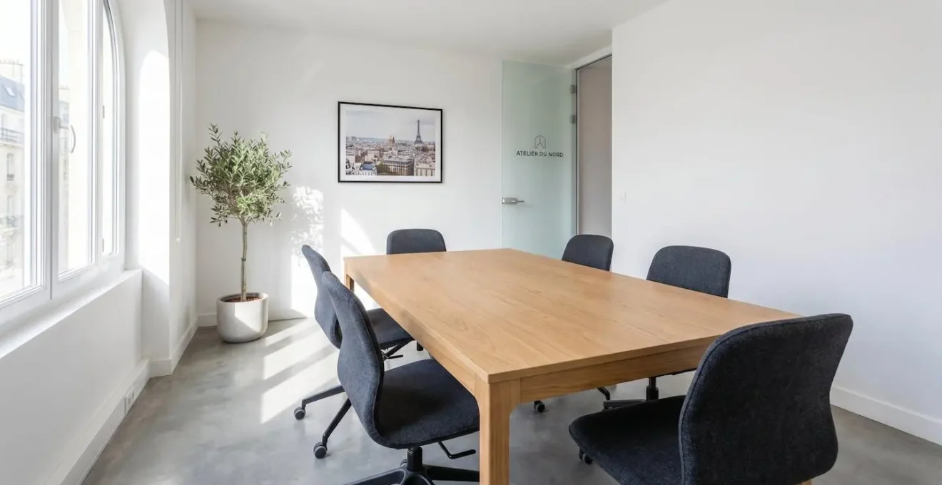Table de réunion rectangulaire en bois clair avec fauteuils ergonomiques gris, salle lumineuse de taille moyenne
